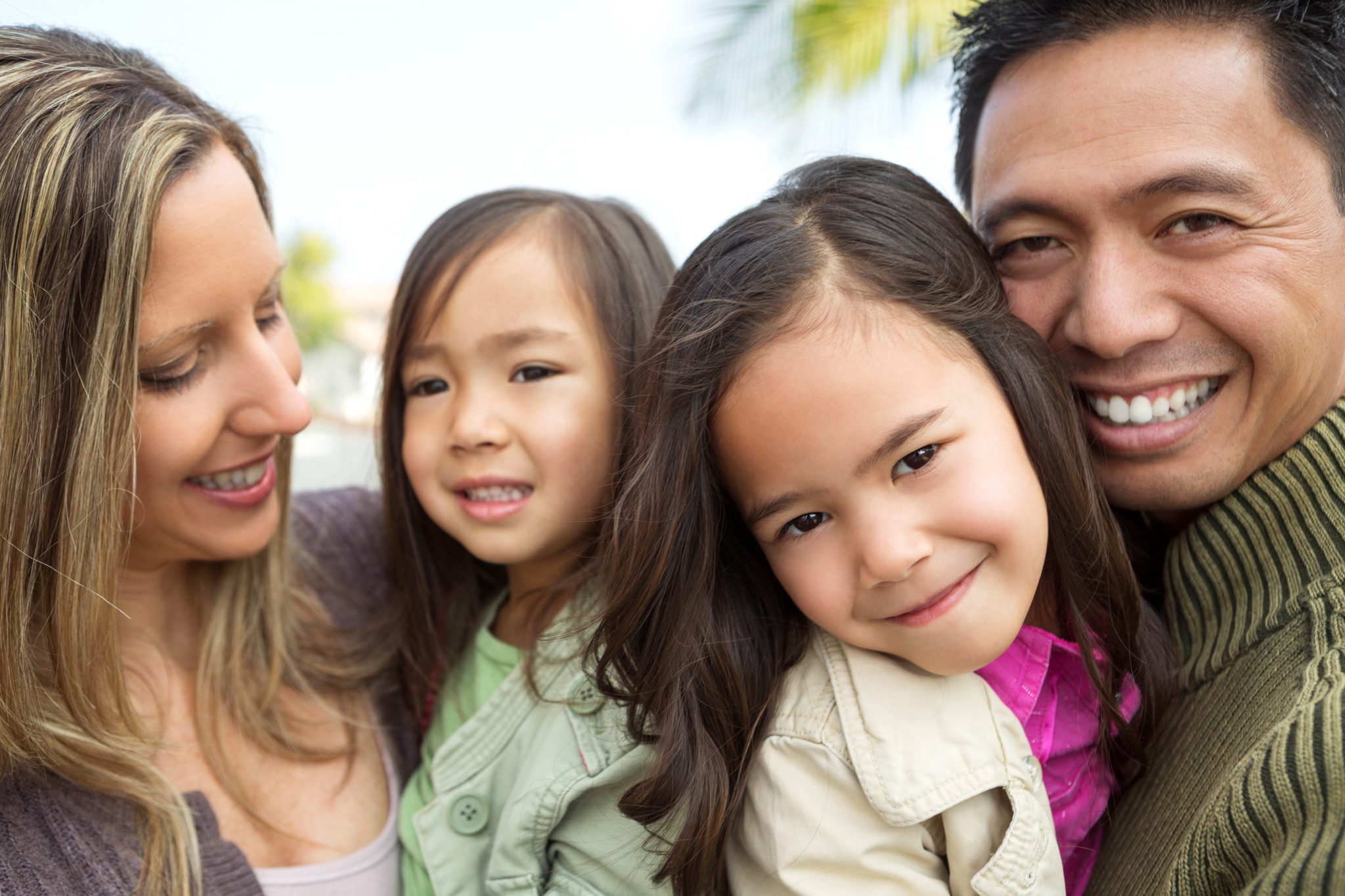 Happy multicultural family with two daughters.