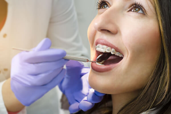 Dentist reviewing a patients' braces.