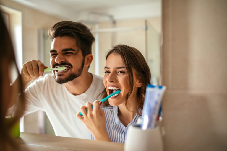 Couple brushing teeth.