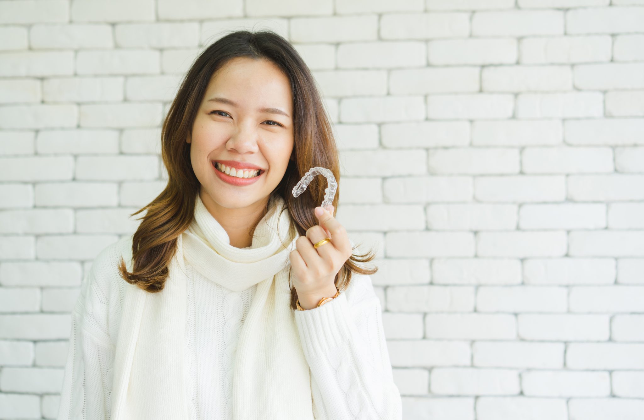 Woman holding her clear aligners